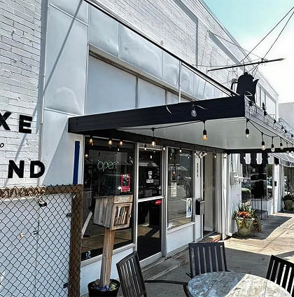Storefront with outdoor seating area on a clear day